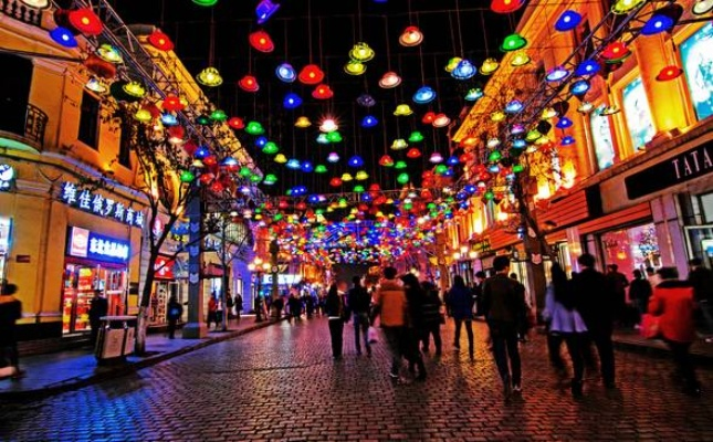 繁华商业街的夜之景，人来人往、霓虹灯闪烁与琳琅满目的店铺